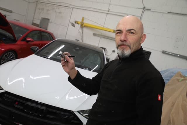 Lackierer bei der Arbeit in der Lackiererei von Fahrzeugtechnik Ebel