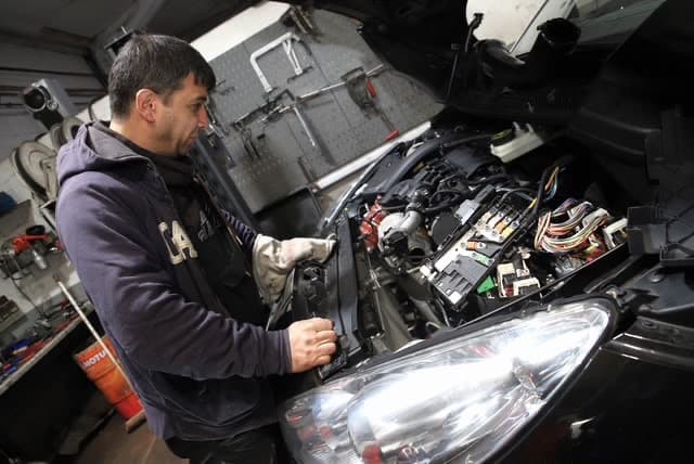 Kfz-Mechaniker bei der Reparatur der Fahrzeugelektrik